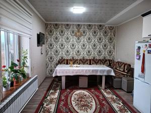 a dining room with a table and a couch at Anarhan Guesthouse Horse riding to Song-Kol and Kilemche in Kyzart