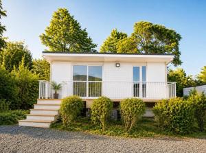 a white house with stairs and bushes at Le Chalet Bellevue, Vue Panoramique, Piscine et Clim in Ayen