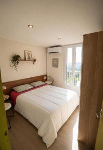 a bedroom with a large white bed and a window at Le Chalet Bellevue, Vue Panoramique, Piscine et Clim in Ayen +9 photos