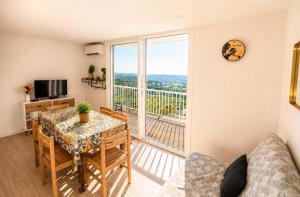 a dining room with a table and a large window at Le Chalet Bellevue, Vue Panoramique, Piscine et Clim in Ayen