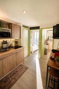 a kitchen with wooden cabinets and a living room at Le Chalet Bellevue, Vue Panoramique, Piscine et Clim in Ayen