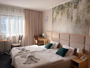 a hotel room with a bed and a table at Great Polonia Silesian Economy Hotel in Katowice