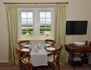 a dining room with a table and a window at Kates Cottages Bracken Lodge in Spott