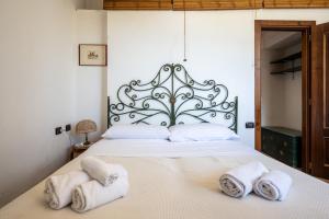 a bedroom with a large white bed with towels on it at Casa Clotilde - nel Cuore di Capri in Capri