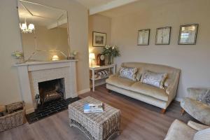 a living room with a couch and a fireplace at Kates Cottages Bracken Lodge in Spott