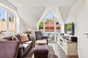 a living room with a couch and chairs and windows at Amelie in Greetsiel