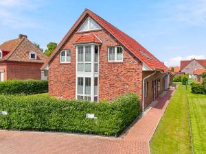 a brick house with a red roof at Amelie in Greetsiel