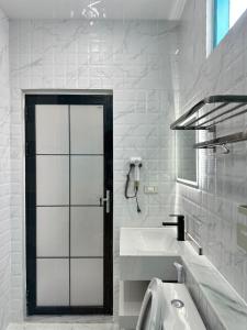 a white bathroom with a tub and a sink at Luangaloun Guesthouse in Luang Prabang