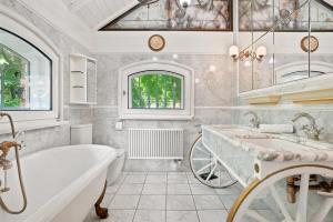 a bathroom with a tub and a sink at Villa Aurum in Greetsiel +37 photos