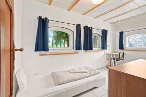 a bathroom with blue curtains and a bath tub at Villa Aurum in Greetsiel