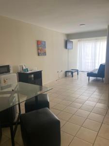 a living room with a glass table and chairs at Apart Hotel Astore in Antofagasta