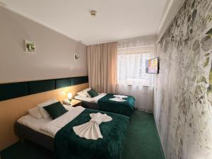 ein Hotelzimmer mit zwei Betten, auf denen Handtücher liegen in der Unterkunft Great Polonia Silesian Quality Hotel in Kattowitz + 79 Fotos