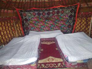 two beds sitting next to each other in a room at Yurt camp Marat Son-Kul in Song-Kul
