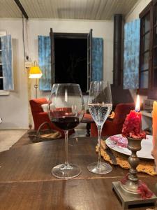 two glasses of wine sitting on a wooden table at Piccola Cucina: Casa centenária Vale dos Vinhedos in Garibaldi +36 photos