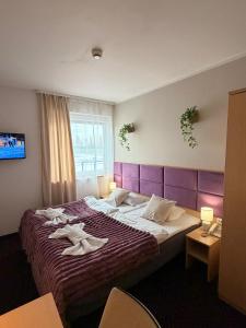ein Hotelzimmer mit einem Bett, auf dem Handtücher liegen in der Unterkunft Great Polonia Silesian Quality Hotel in Kattowitz