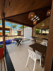 an outdoor patio with tables and chairs and windows at Pousada Pontal RJ in Rio de Janeiro