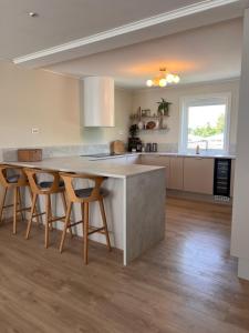 a kitchen with a large island with chairs around it at Flott hus på Tasta in Stavanger