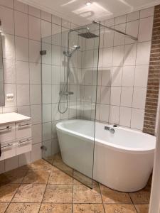 a bathroom with a tub and a glass shower at Flott hus på Tasta in Stavanger