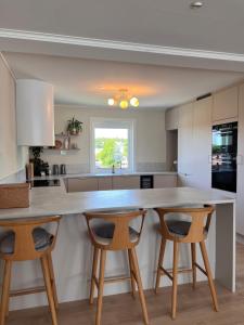 a kitchen with a large counter and two chairs at Flott hus på Tasta in Stavanger +15 photos