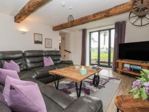 a living room with a leather couch and a table at Miller's Wheel in Harrogate