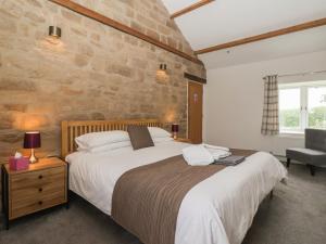 a bedroom with a large bed and a stone wall at Miller's Wheel in Harrogate