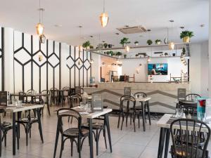 a restaurant with tables and chairs in a room at Ibis Meknès in Meknès