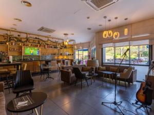 a restaurant with a bar with tables and chairs at Ibis Meknès in Meknès