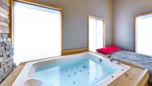 a large bath tub in a room with two windows at Ulsan Lime House in Ulsan