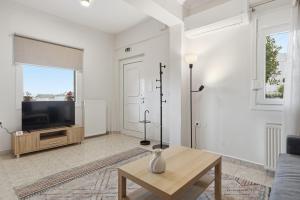 a living room with a tv and a table at Calma Ioannina Apartment in Ioannina