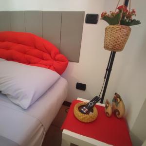 a bedroom with a bed and a red table with a lamp at Leo House in Trezzo sullʼAdda