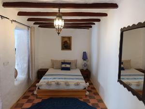 a bedroom with two beds and a mirror at daryemma2 in Asilah