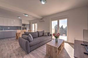 a living room with a couch and a table at Villa Sandy Apartments in Tivat