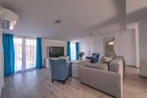 a living room with a couch and a tv at Villa Sandy Apartments in Tivat