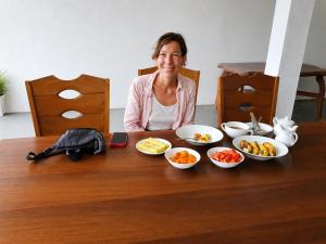 a woman sitting at a table with plates of food at Villa Ocean Gift in Galle