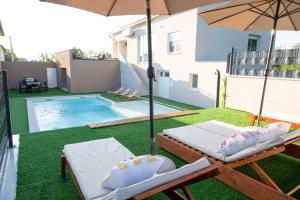 a pool with two lounge chairs and an umbrella at Villa Bella in Čitluk