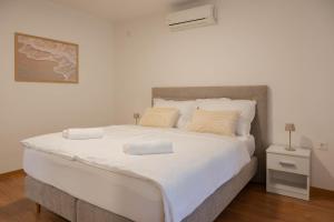 a large white bed with two pillows on it at Villa Bella in Čitluk