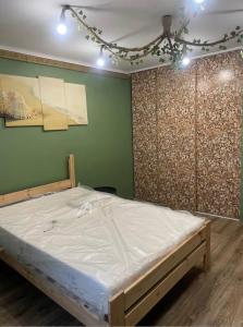 a bed in a room with a green wall at Second&Home 3 in Kalisz +5 photos