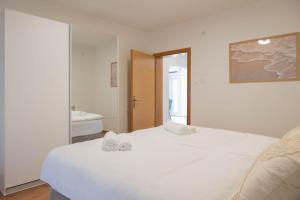 a bedroom with a white bed and a bathroom at Villa Bella in Čitluk