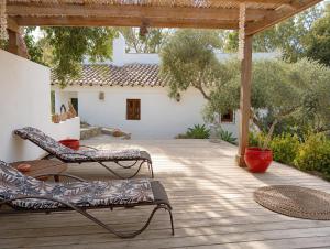 a patio with two lounge chairs on a wooden deck at Finca Altozano - Private pool in Valle de Abdalagís