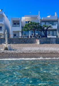 a view of a beach with buildings in the background at Skizenas Waterfront Apartments in Haraki