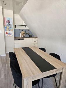 a dining room table with black chairs in a kitchen at FeWo Zimmer Waldmohr in Waldmohr