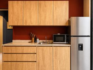 a kitchen with wooden cabinets and a stainless steel refrigerator at Casa DUALIA in San Miguel de Allende +5 photos