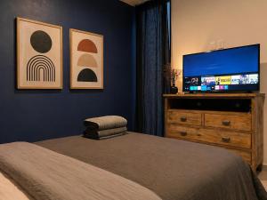 a bedroom with a bed and a flat screen tv at Casa DUALIA in San Miguel de Allende