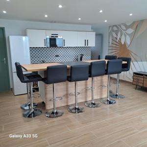 a kitchen with a wooden table and black chairs at LE 37 croix in Gennes