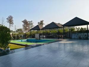 a swimming pool in a yard with a pavilion at Crystal Garden in Lalru +10 photos