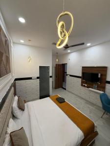 a bedroom with a large bed and a chandelier at Crystal Garden in Lalru