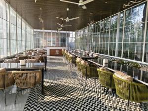 a restaurant with tables and chairs and windows at Crystal Garden in Lalru