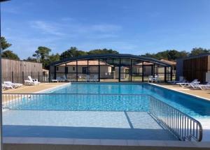 a large swimming pool in front of a building at Cottage Le Colibri au calme - City-Parc- piscine à partir 1 juillet 11 kms océan in Saubrigues