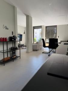 a white living room with a table and chairs at Notos Suites in Athens
