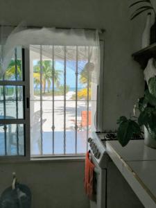 a kitchen with a window with a view of a beach at Cozy beachfront house Cocomar in San Crisanto